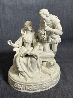 figurine représentant un homme et une femme assis sur une chaise
