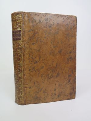 an old book sitting on top of a white table next to a white wall