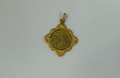 a gold pendant with a picture of a woman on it
