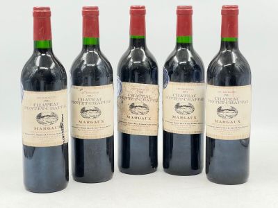 quatre bouteilles de vin sont alignées sur une surface blanche