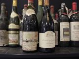 bottles of wine are lined up on a shelf in a room