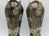two vases that are sitting side by side on a white surface