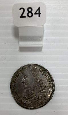un gros plan d'une pièce de monnaie posée sur une surface blanche, avec une étiquette