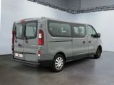 grey van parked in a large room with a white wall