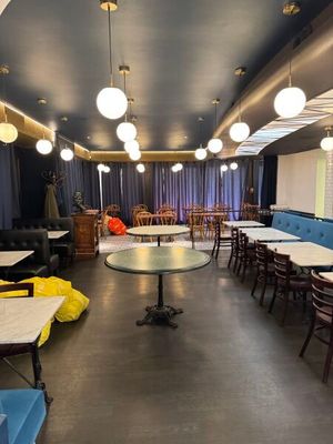 de nombreuses tables et chaises dans une pièce où les chaises sont bleues et jaunes