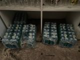 many bottles of water sitting on a shelf in a room