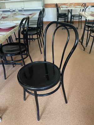 des tables et des chaises dans un restaurant, avec un chien assis au milieu de la salle