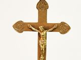 a gold cross hanging from a wire with a cross on it