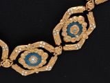 an image of a gold and blue necklace on a black surface