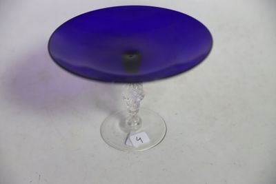 un plat à gâteau en verre bleu posé sur une table blanche