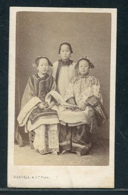 une vieille photo en noir et blanc représentant trois enfants assis sur un banc