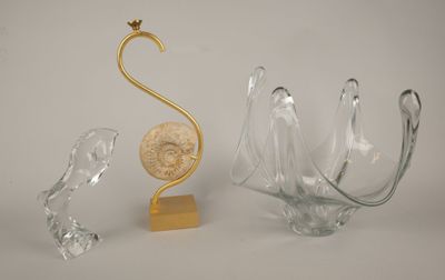trois morceaux de verre et une sculpture en or posés sur une table