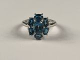 un gros plan d'une bague ornée de deux pierres bleues