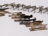 a lot of metal horses that are lined up together