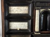 a black and white chest of drawers with a clock on top