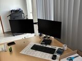 a desk with two monitors and a keyboard on it