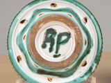 a green and white plate sitting on top of a wooden table