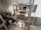 a large stainless steel counter in a kitchen with pots and pans on it