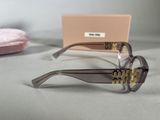 sunglasses with gold letters on them sitting on a table next to a pink box