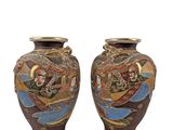pair of decorative vases with asian scenes on them on a white background