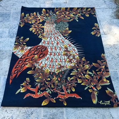 un tapis bleu et orange sur lequel est représenté un oiseau