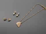 a gold necklace and earring set with a heart shaped pendant