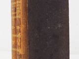 an old book sitting on top of a table next to a white wall