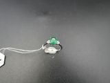 a close up of a ring with a green stone on it