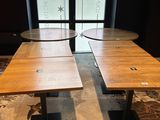 two wooden tables sit in front of a window in a room