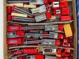 une boîte remplie de petits trains et d'autres véhicules miniatures