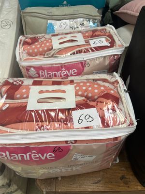 several bags of baby clothes sitting on a shelf in a store