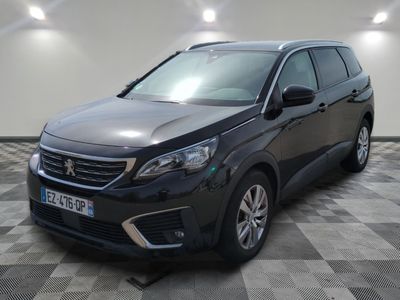 la voiture noire est garée sur le sol en damier d'un garage