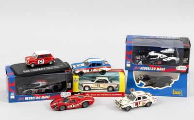 Plusieurs petites voitures sont posées dans une boîte sur une surface blanche.