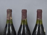 three bottles of wine are lined up on a table