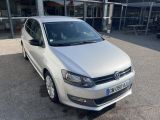 the white volkswagen polo is parked in front of a building