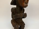 une vieille statue en bois représentant une femme coiffée d'un chapeau