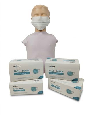 une personne portant un masque à côté de trois boîtes de masques