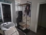 une photo d'un salon de coiffure avec un fauteuil et un lavabo