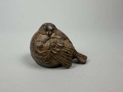 a close up of a bird figurine on a white surface
