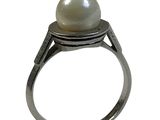 une image représentant une bague sertie d'une perle, sur fond blanc