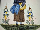 une assiette sur laquelle est représentée une femme tenant un sac bleu