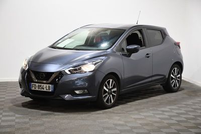 un Nissan Micvan gris garé sur un sol à damier