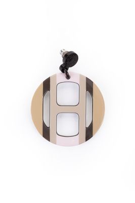 un gros plan d'un pendentif circulaire blanc et noir sur fond blanc