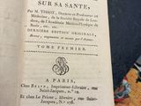 un livre ouvert posé sur une table à côté d'une pile de livres