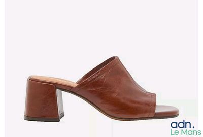 un gros plan sur une paire de mules marron sur fond blanc