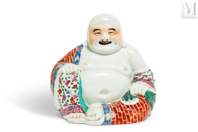 une figurine représentant un Bouddha souriant assis sur un coussin