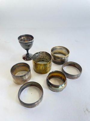 un ensemble de tasses et de bols en argent posés sur une table blanche