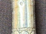 a silver spoon with a design on it sitting on a table