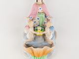 a figurine of a woman holding a basket of flowers