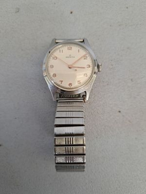 une photo d'une montre-bracelet posée sur une surface blanche